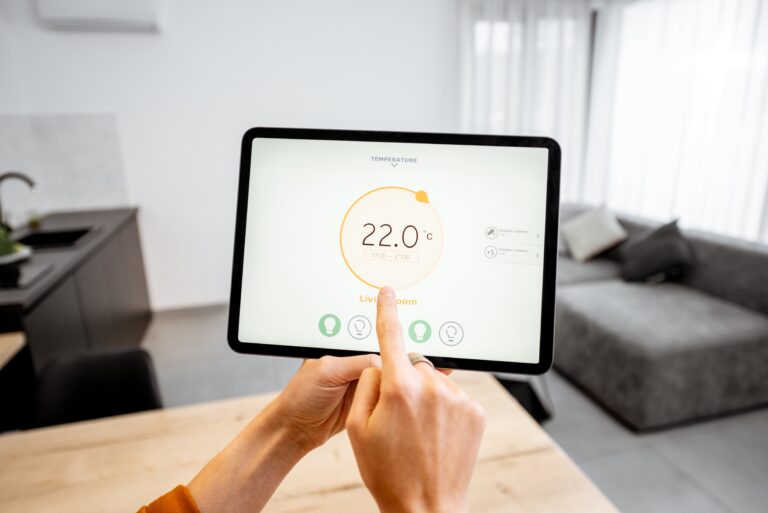 A homeowner controlling smart home lighting and temperature with a tablet.