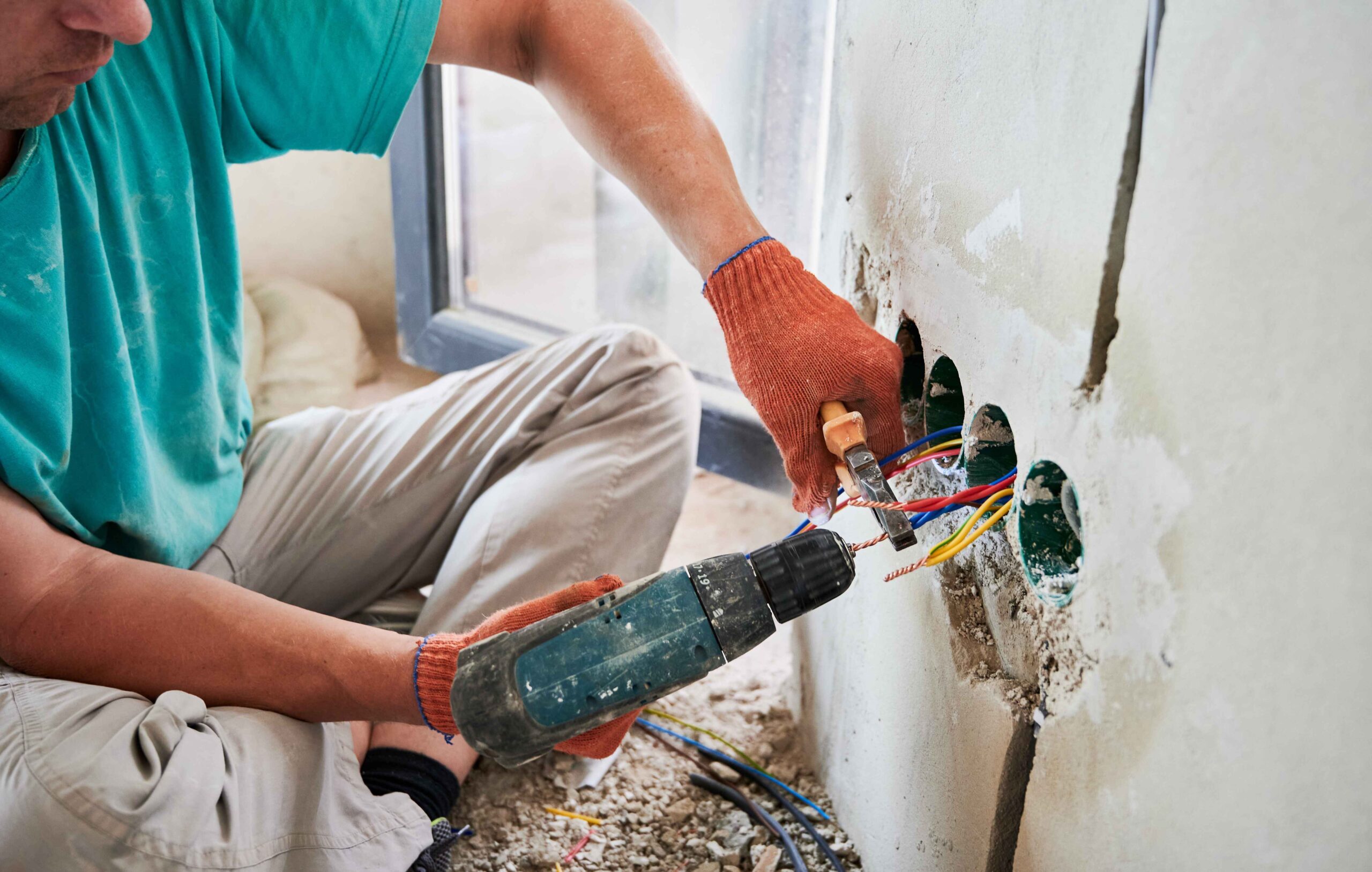 male electrician using electric heat gun and plier